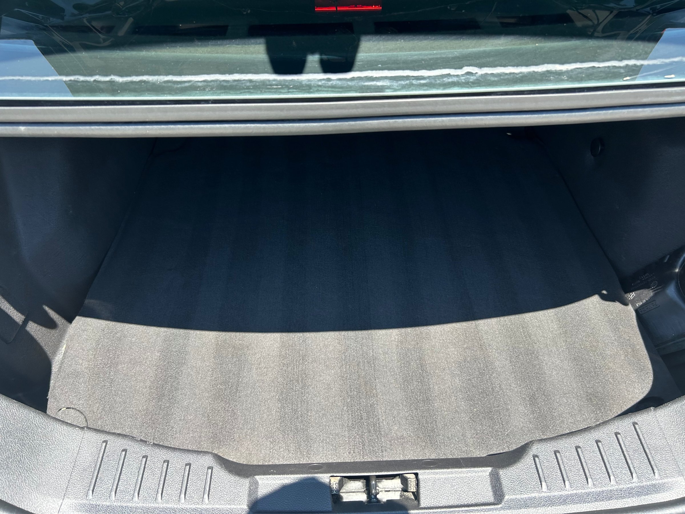 Spotless, freshly detailed empty sedan trunk with clean carpet and trim