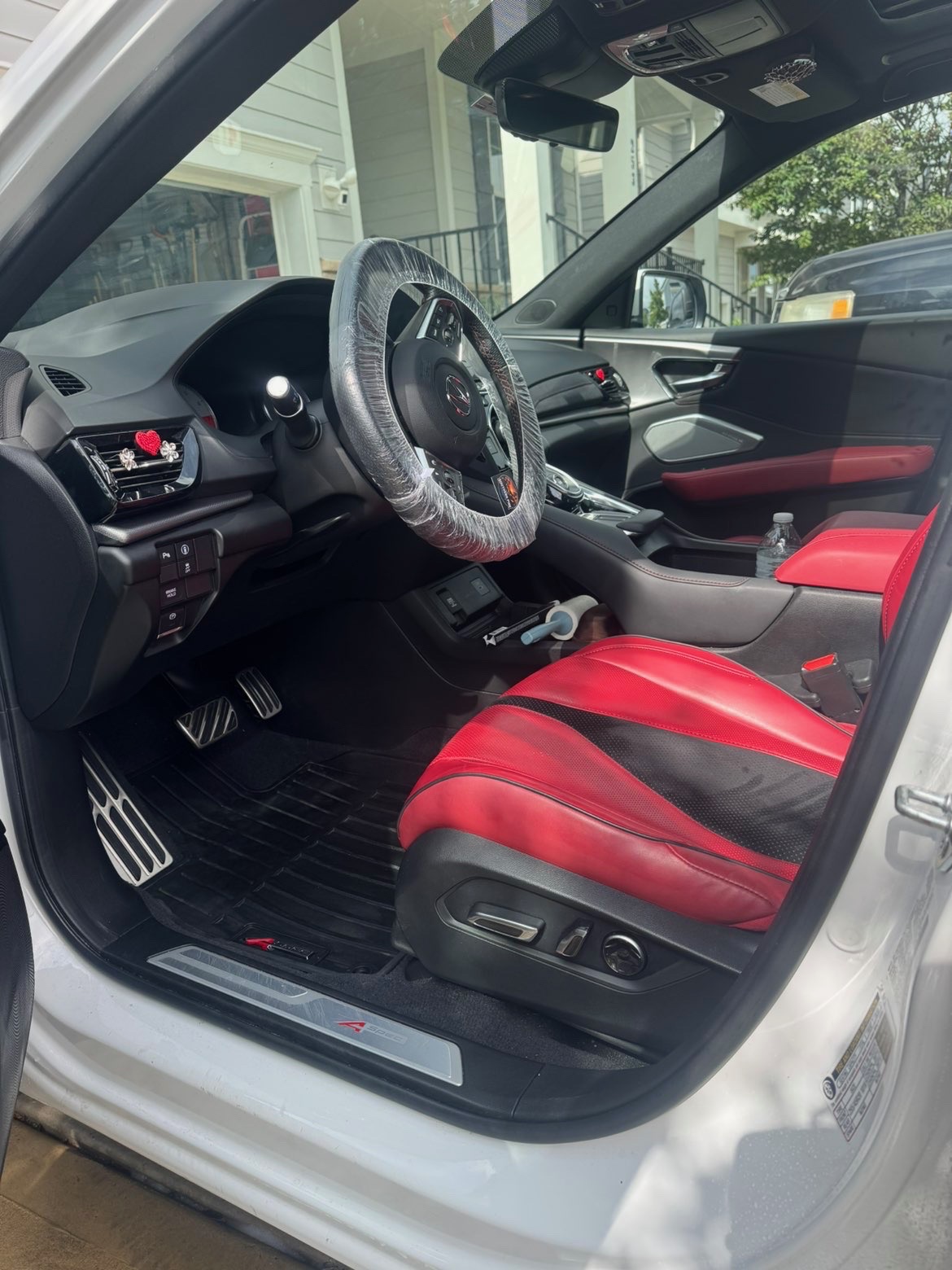 Sport seat interior mid-detail with a protective wrap still on the steering wheel