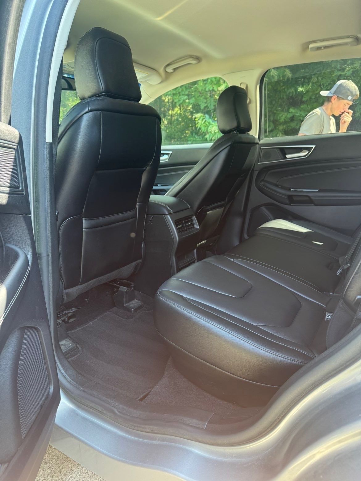 Detailed SUV rear seat area with one seat folded down, clean black leather